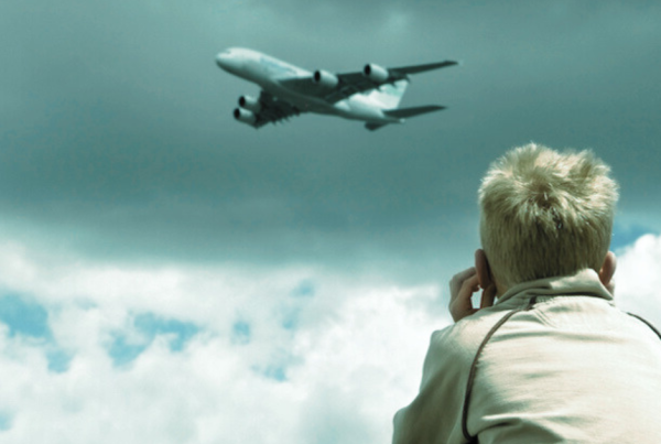 enfant se bouchant le soreilles à cause du bruit d'un avion
