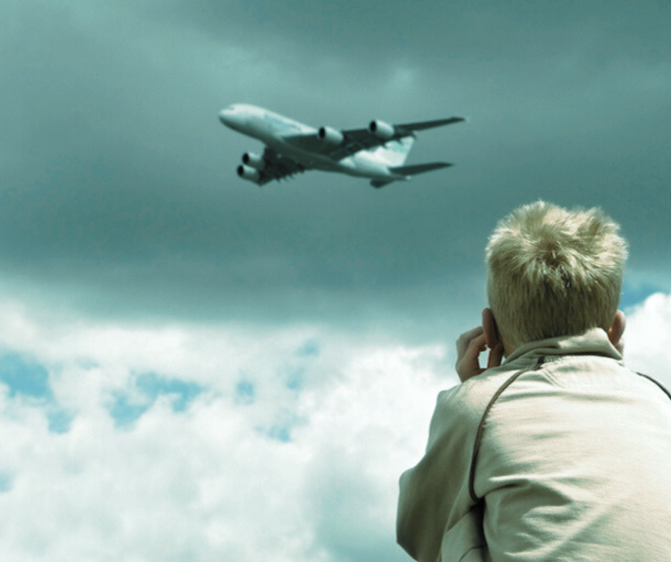 enfant se bouchant le soreilles à cause du bruit d'un avion
